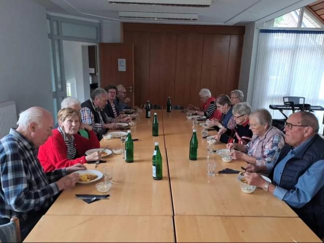 Menschen sitzen zusammen und essen