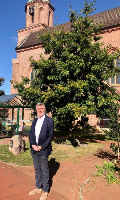 Der neue Landpfarrer der Gemeinde, Bernd Strickmann, stehend vor der Holdorfer Kirche.
