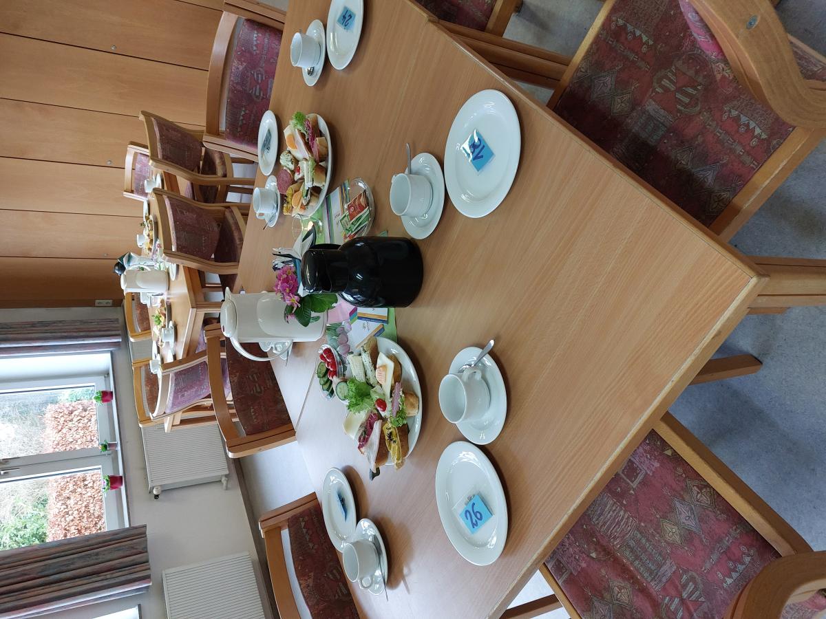 liebevoll gedeckter Tisch mit Canapés, Kaffee und Blumen